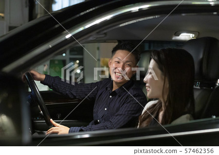 年輕的男人和女人在晚上在車裡愉快的交談 57462356