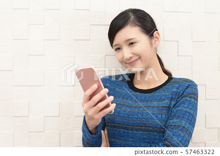 A smiling woman with a smartphone A smiling woman with a smartphone 57463322