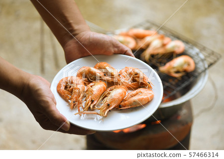 hand holding shrimp grilled prawns cooked in the 57466314