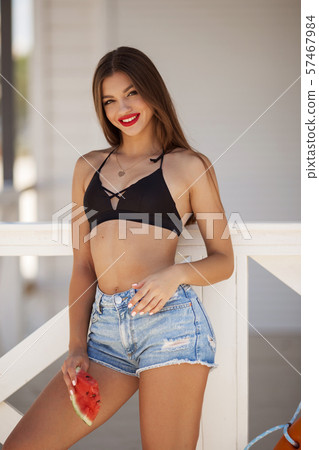 Fashion portrait of a sexy girl with watermelon on the beach 57467984