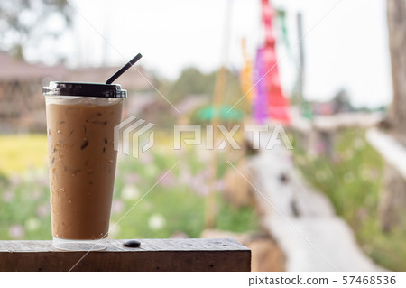 Iced coffee on the wooden floor behind a paddy field and colorful fabrics. Iced coffee on the wooden floor behind a paddy field and colorful fabrics. 57468536