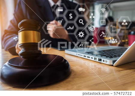 Justice and law concept. Male judge in a courtroom with the gavel working with digital tablet computer docking keyboard on wood table. 57472722