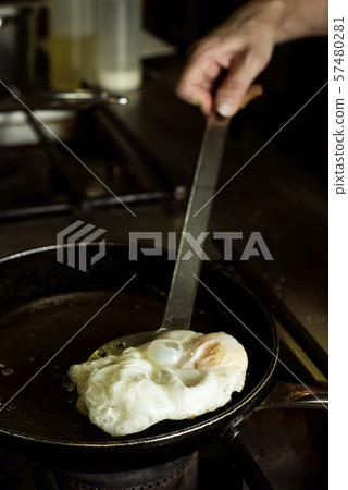 frying an egg in a professional kitchen frying an egg in a professional kitchen 57480281