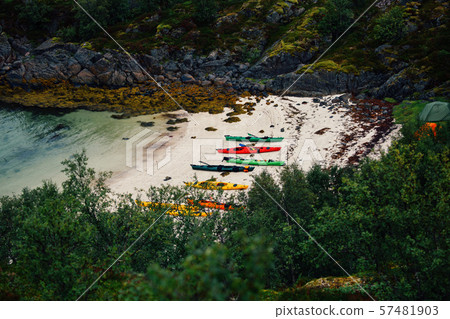 Photo of picturesque mountainous area, colorful kayaks on sandy seashore in Norway. Photo of picturesque mountainous area, colorful kayaks on sandy seashore in Norway. 57481903