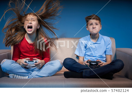 Computer game competition. Gaming concept. Excited girl playing video game with joystick 57482124