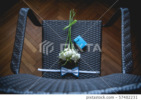 The groom is gathering in the morning. Wedding bouquet, handkerchief butterfly and gift box on the The groom is gathering in the morning. Wedding bouquet, handkerchief butterfly and gift box on the 57482231