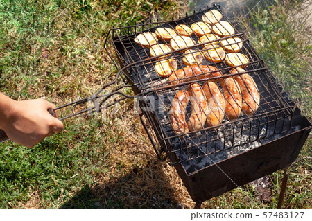 cooking fried potatoes with grilled sausages 57483127