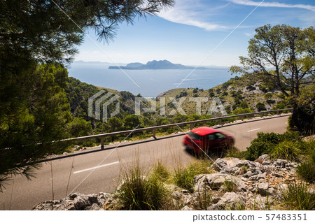 Road to Cap Formentor with red motion blurred car Road to Cap Formentor with red motion blurred car 57483351