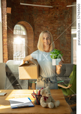 A young businesswoman moving in office, getting new work place A young businesswoman moving in office, getting new work place 57484000