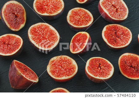 Ripe Figs. Creative diagram of chopped figs on a black textural background in the form of a texture Ripe Figs. Creative diagram of chopped figs on a black textural background in the form of a texture 57484110