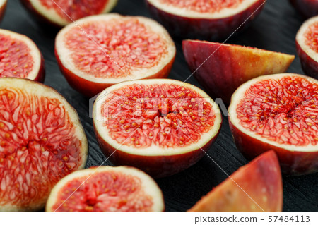 Ripe Figs. Creative diagram of chopped figs on a black textural background in the form of a texture 57484113