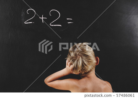 little boy without T-shirt thinks on blackboard little boy without T-shirt thinks on blackboard 57486061