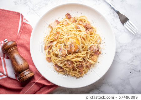 carbonara spaghetti with raw egg yolk on top 57486899
