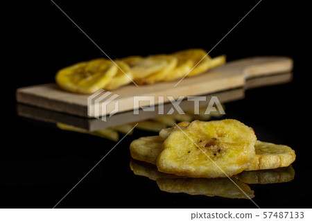 Yellow dry banana isolated on black glass Yellow dry banana isolated on black glass 57487133