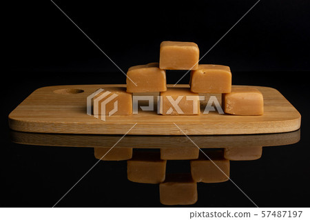Sweet caramel candy isolated on black glass Sweet caramel candy isolated on black glass 57487197