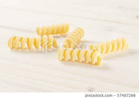 Raw pasta fusilli bucati on grey wood Raw pasta fusilli bucati on grey wood 57487266