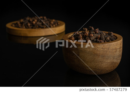Dry brown clove isolated on black glass Dry brown clove isolated on black glass 57487279