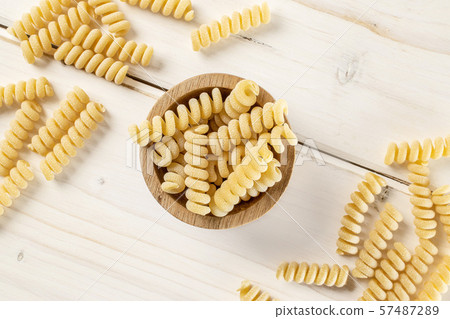 Raw pasta fusilli bucati on grey wood Raw pasta fusilli bucati on grey wood 57487289