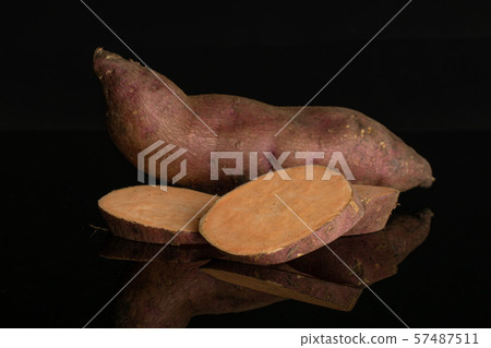 Fresh sweet potato isolated on black glass Fresh sweet potato isolated on black glass 57487511