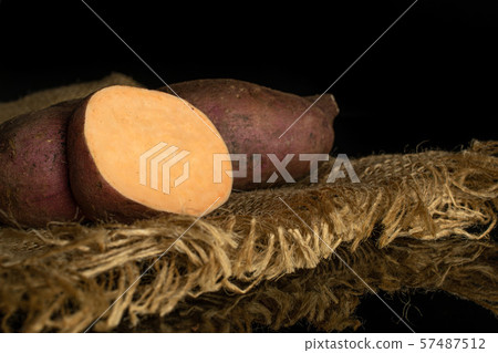 Fresh sweet potato isolated on black glass Fresh sweet potato isolated on black glass 57487512