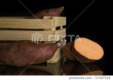 Fresh sweet potato isolated on black glass Fresh sweet potato isolated on black glass 57487526