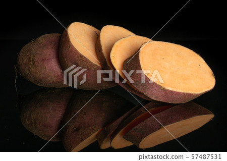 Fresh sweet potato isolated on black glass Fresh sweet potato isolated on black glass 57487531