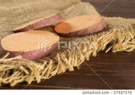 Fresh sweet potato on brown wood Fresh sweet potato on brown wood 57487576