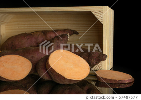 Fresh sweet potato isolated on black glass Fresh sweet potato isolated on black glass 57487577