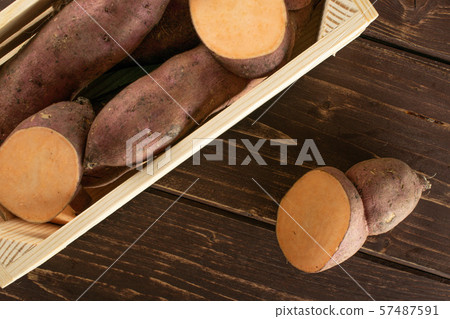 Fresh sweet potato on brown wood Fresh sweet potato on brown wood 57487591