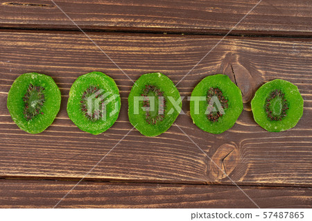 Sweet candied kiwifruit on brown wood 57487865