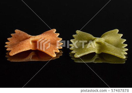 Raw farfalle tricolore isolated on black glass Raw farfalle tricolore isolated on black glass 57487878