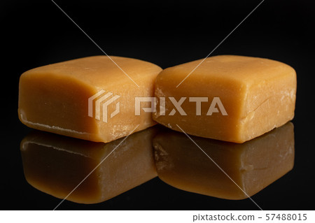 Sweet caramel candy isolated on black glass 57488015