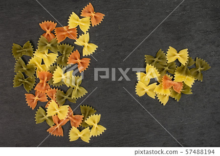 Raw farfalle tricolore on grey stone Raw farfalle tricolore on grey stone 57488194