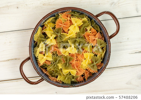 Raw farfalle tricolore on grey wood Raw farfalle tricolore on grey wood 57488206