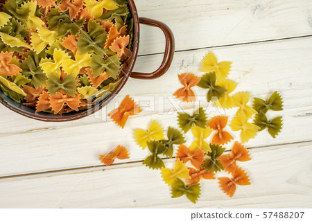 Raw farfalle tricolore on grey wood Raw farfalle tricolore on grey wood 57488207