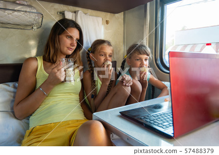 Mom drinks tea, children eat ice cream on a train, Mom drinks tea, children eat ice cream on a train, 57488379