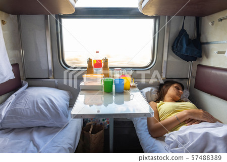 Interior of a reserved seat train car, a girl Interior of a reserved seat train car, a girl 57488389