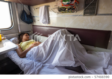 A young girl sleeps on a lower bunk in a reserved A young girl sleeps on a lower bunk in a reserved 57488390