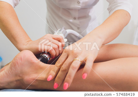 Cropped view of cosmetologist with roller doing buttocks starvac massage. 57488419