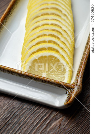 Thin sliced lemon on a brown wooden background. restaurant menu Thin sliced lemon on a brown wooden background. restaurant menu 57490620