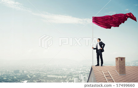 Young businessman with flag presenting concept of leadership. Mi 57499660