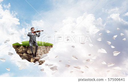 Handsome businessman play his melody and paper planes fly around 57500641