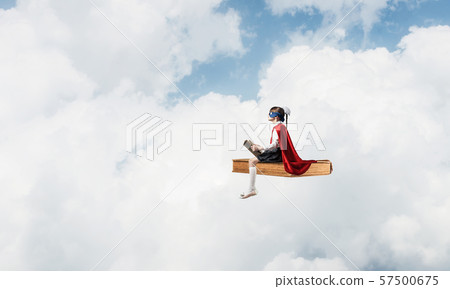 Girl power concept with cute kid guardian against cloudscape background Girl power concept with cute kid guardian against cloudscape background 57500675