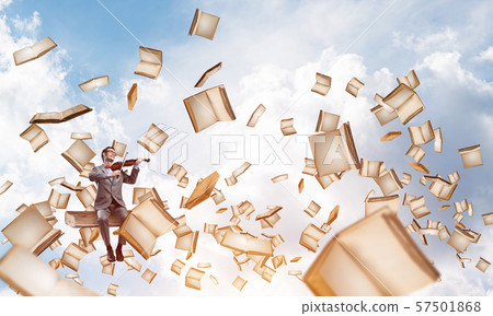 Handsome violinist sitting on book and play his melody 57501868