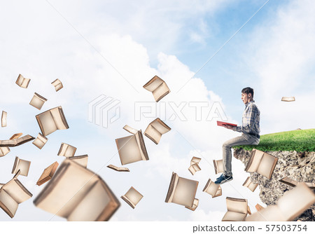 Man reading book and many of them flying in air Man reading book and many of them flying in air 57503754