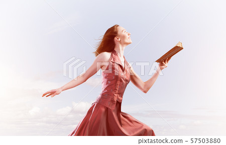 Girl against cloudy sky with opened book in palm as idea for knowledge Girl against cloudy sky with opened book in palm as idea for knowledge 57503880