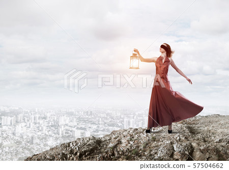 Attractive girl muse with old lantern in hand at summer day 57504662