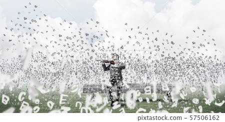Handsome violinist in park on wooden bench play his melody 57506162