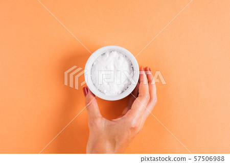 Baking soda in bowl on orange 57506988