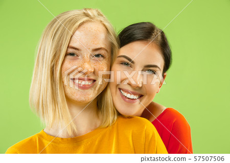 Portrait of pretty girls isolated on green studio background 57507506